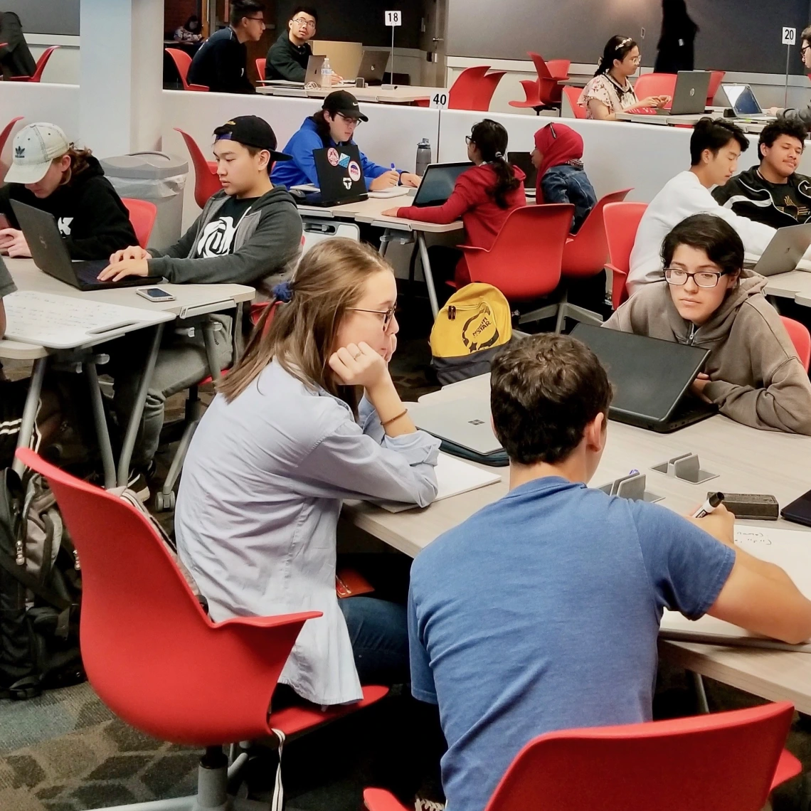 students working on laptops in a large collaborative learning classroom