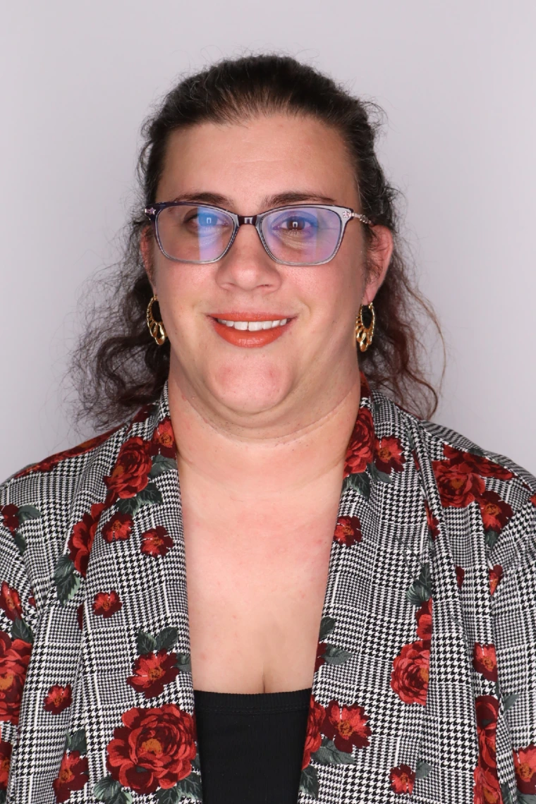 headshot of sam in a plaid blazer with flower print