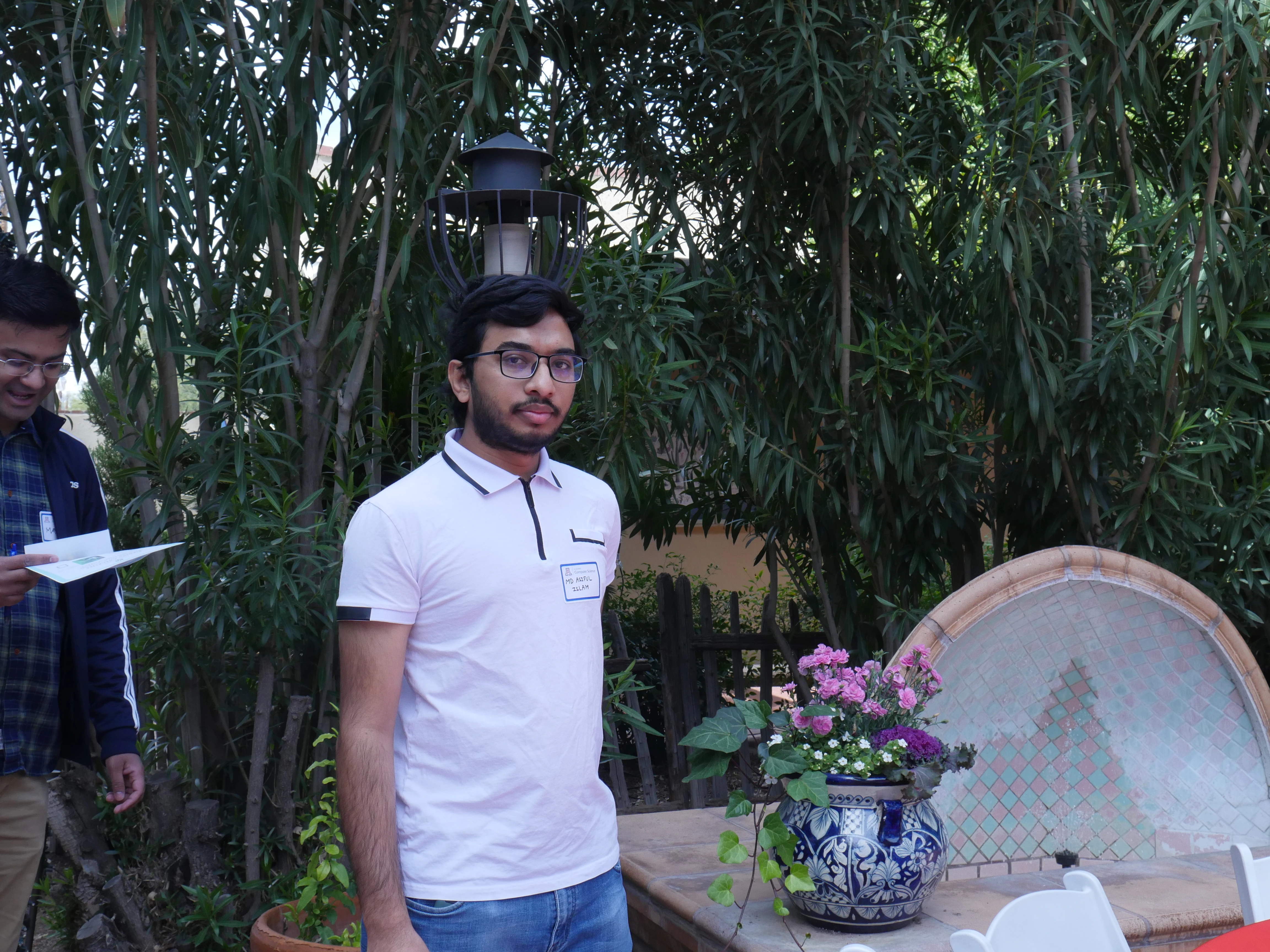 student in polo in TBG by a lamppost