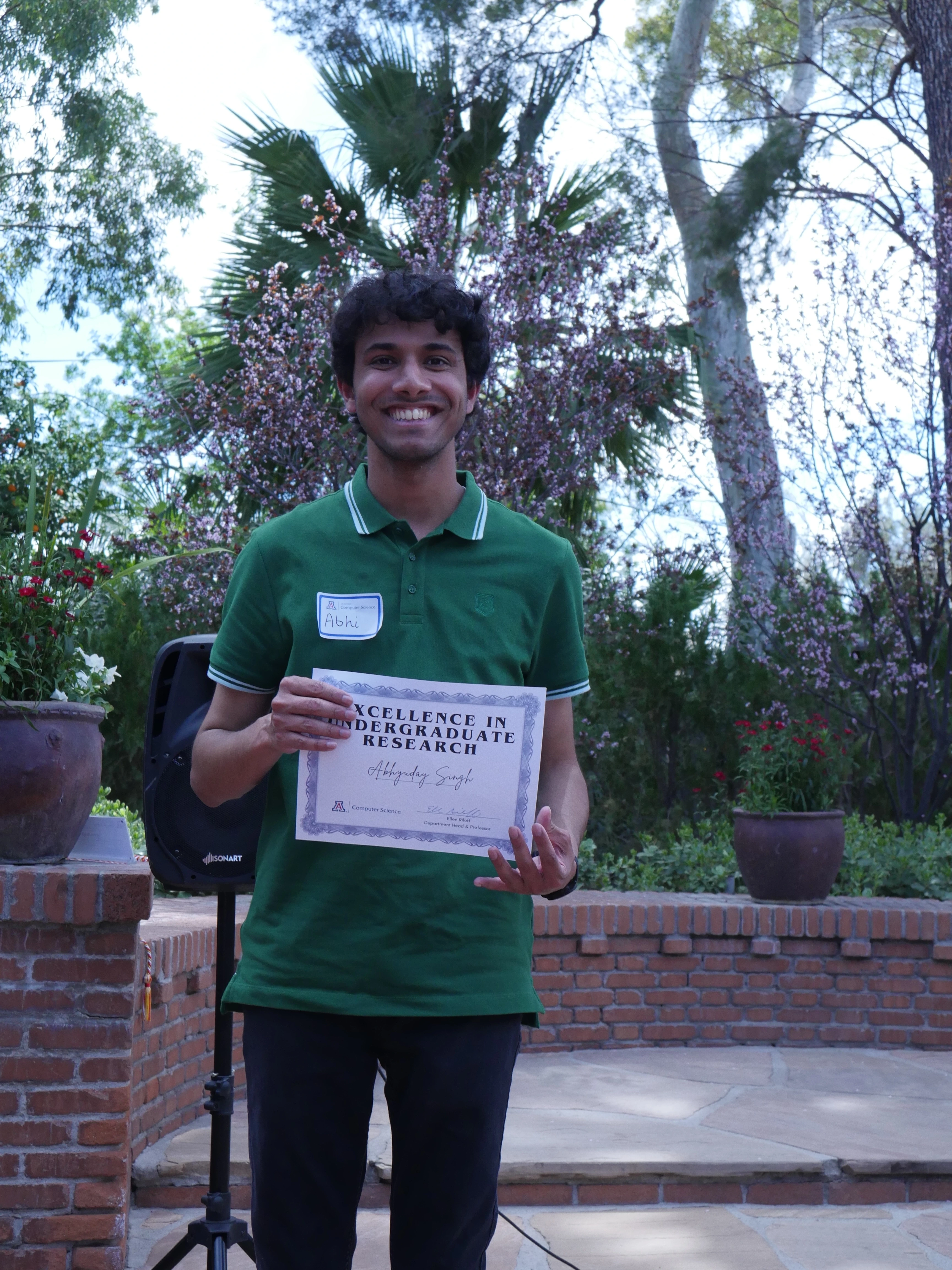 Abhi displays his Excellence in Undergraduate Research certificate