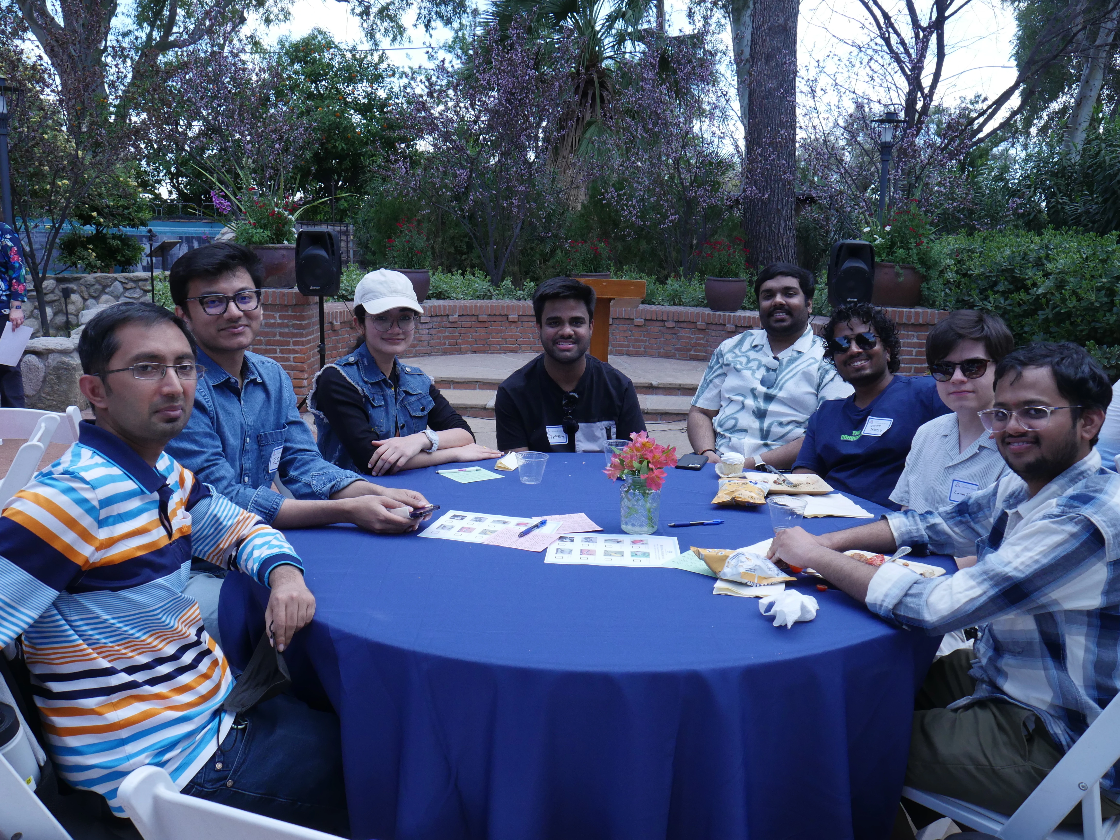 8 event attendees at a table with a blue cloth